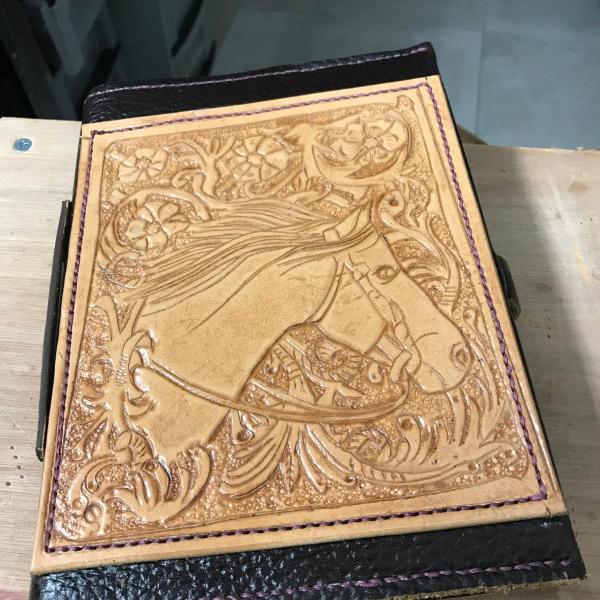 Boekomslag met blank leder versiering.